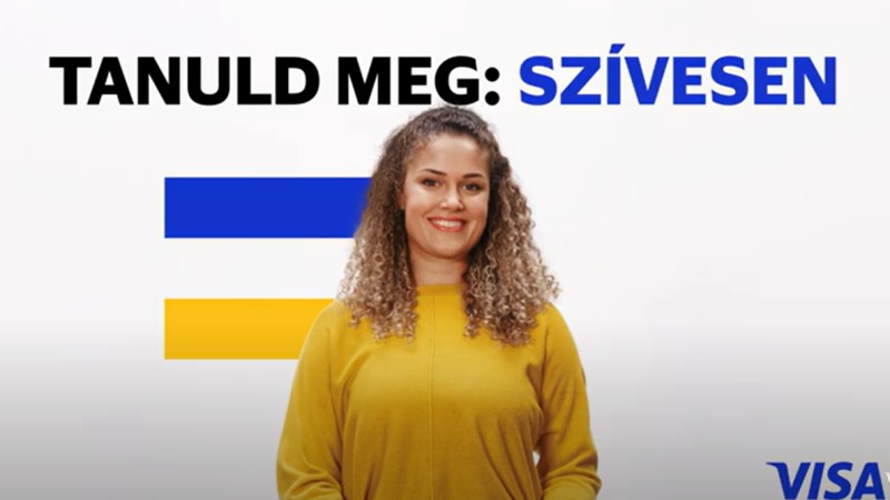 woman in yellow in front of visa flag and tanuld meg koszonom