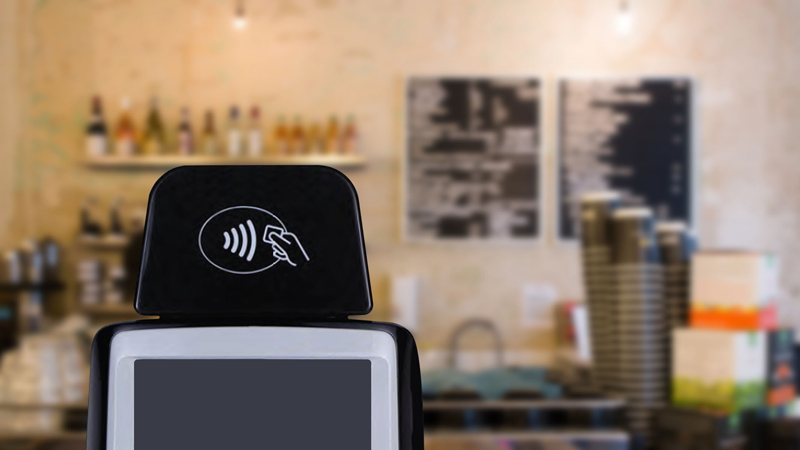 Closeup of a POS system in a coffee shop displaying the Tap to Pay logo. Closeup of a POS system in a coffee shop displaying the Tap to Pay logo.