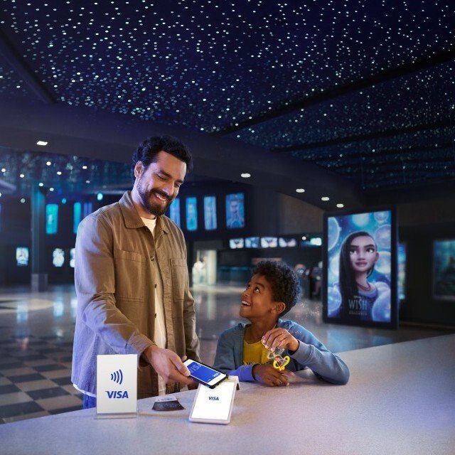 man and child making contactless mobile payment