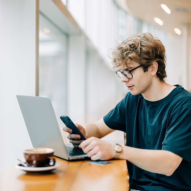 man using mobile and laptop